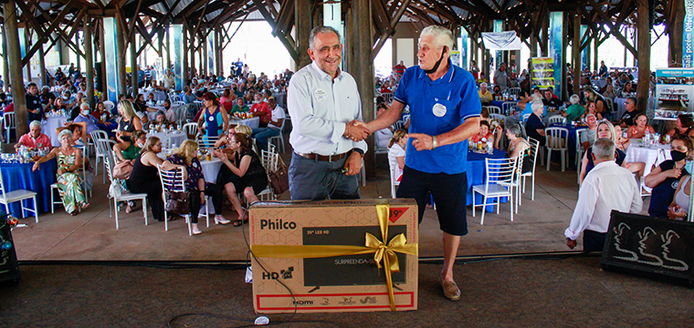 O presidente do SINTETEL, Gilberto Dourado, entrega a TV para  Ccero Pereira da cidade de Lins