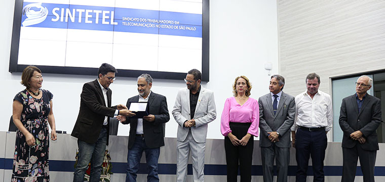 Gilberto Dourado, presidente do SINTETEL, recebe das mos do vereador Jos Luiz, a placa em homenagem aos 81 anos do Sindicato