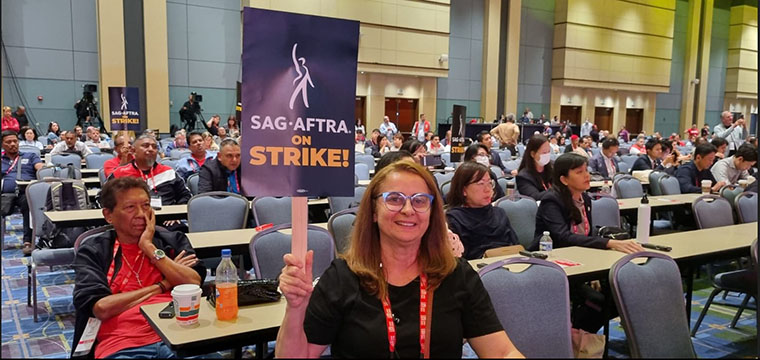 Dirigente do SINTETEL e da FENATTEL, Cristiane do Nascimento, com cartaz em apoio  greve dos trabalhadores de mdias, cinema e TV dos EUA
